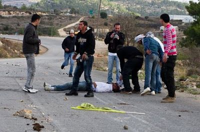 Youths-stand-around-Mustafa-Tamimi.jpg