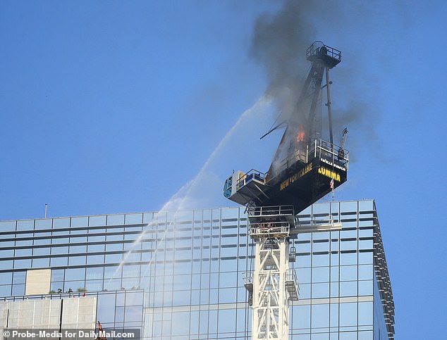 73634459-12339843-Firefighters_are_seen_spraying_water_on_the_crane_in_a_bid_to_st-a-19_16903760.jpg