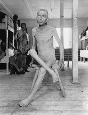 An emaciated Hungarian Jewish survivor sits on a stool in the infirmary barracks for Jewish pris.jpg