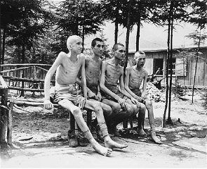 Four emaciated survivors sit outside in the newly liberated Ebensee concentration camp..jpg