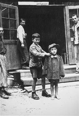 hildren survivors stand in front of a barracks in the newly liberated Ebensee concentration camp.jpg