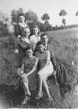 A group of young Jewish men and women pose in a field in the Kozienice ghetto.jpg