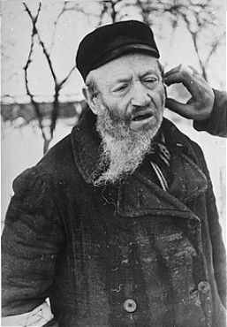 A religious Jew in Hrubieszow endures the humiliation of having his beard cut off.jpg