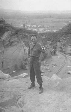 An American soldier poses near the edge of the 'parachute jump' at the Wiener Graben quarry.jpg