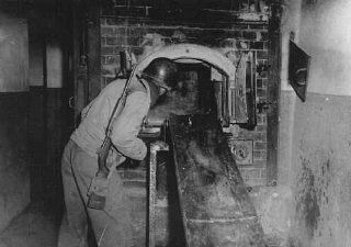 An American solider looks at the Mauthausen crematorium during the liberation.jpg