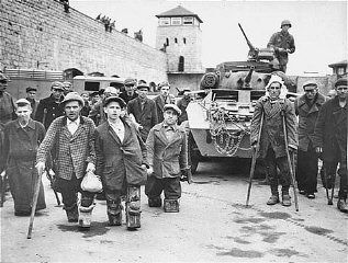 Handicapped Soviet and Polish prisoners in front of a tank of the 11th Armored Division, U.S. Th.jpg