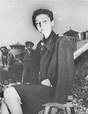 The Hungarian Jewish stage actress from Budapest, Livia Nador, sits outside on a stool.jpg
