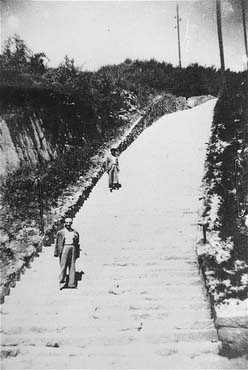 Two survivors pose on the stone 'steps of death' (Todesstiege).jpg