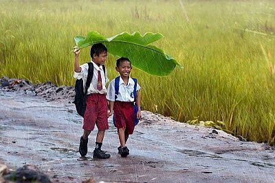 two-kids-under-banana-leaf-rain-indonesia.jpg
