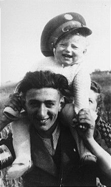 minsk ghetto policeman carries his young cousin.jpg