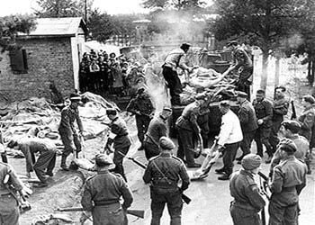 British soldiers guard SS men as they load bodies on trucks.jpg