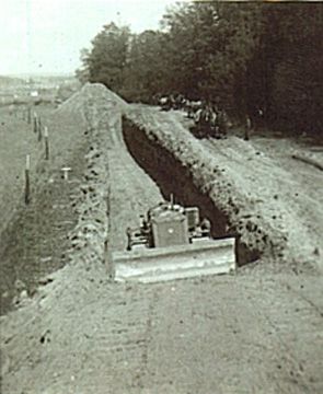 Dachau Concentration Camp Photos and April 29, 1945 Liberation - US Army bulldozer digging trench for mass graves at Leitenberg