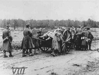 Bergen-Belsen Liberation, April 15, 1945, and Postwar Displaced Persons Camp - a wagon load of corpses being pushed to the mass burial site by Soviet POWs under German guard