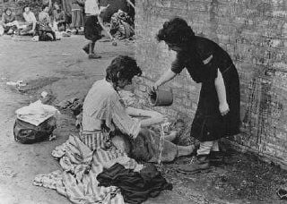Soon after liberation, concentration camp survivors wash each other with some of the site's limi.jpg