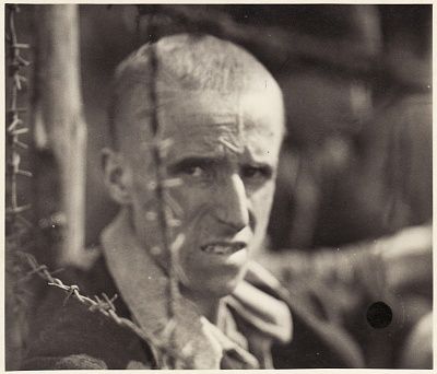 survivor-bergen-belsen-concentration-camp-looks-through-barbed-wire-fence.jpg