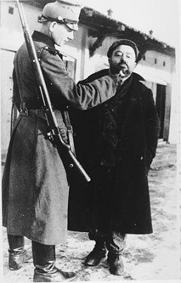 german-policeman-publicly-humiliates-jew-zawiercie-ghetto-shaving-his-beard.jpg