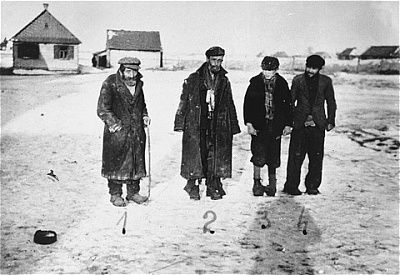 four-jewish-men-pose-unpaved-road-wisznice-ghetto.jpg