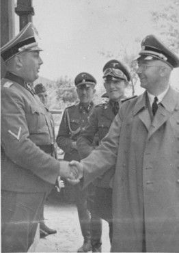 Reichsfuehrer SS Heinrich Himmler (right) shakes the hand of camp commandant Friedrich Warzok du.jpg
