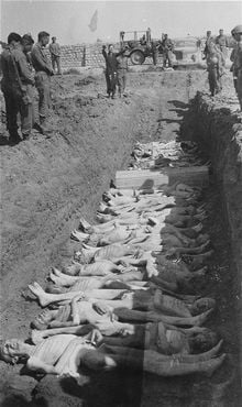 An American Army chaplain recites prayers at an open mass grave in the Gusen concentration camp.jpg