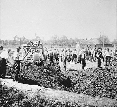 bulldozer-levels-ground-over-already-filled-grave-while-austrian-civilians-prepare-new-.jpg