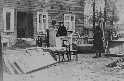 jew-stands-among-disassembled-furniture-outside-house-kovno-ghetto.jpg