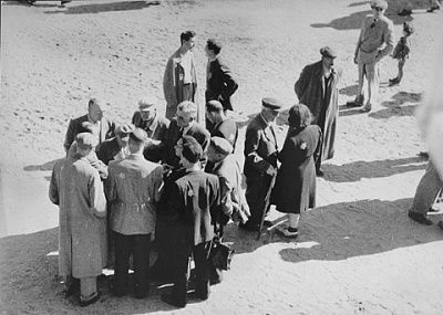 jews-converse-outside-sammelstelle-gathering-place-kovno-ghetto.jpg