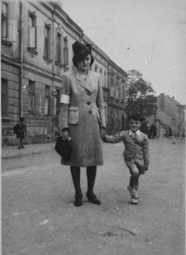 Kraków Ghetto in Podgórze: Life, Deportations and Liquidation, 1941-1943 - A Jewish mother, wearing an armband, walks along a street with her son in the Krakow ghetto