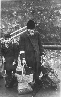 Kraków Ghetto in Podgórze: Life, Deportations and Liquidation, 1941-1943 - An elderly man and child who have been rounded up for deportation wait with their luggage at an
