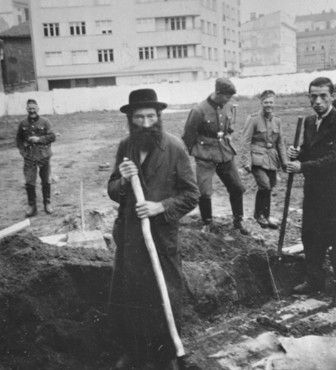 German soldiers amuse themselves while they force Jews to dig ditches in an empty lot in Krakow.jpg