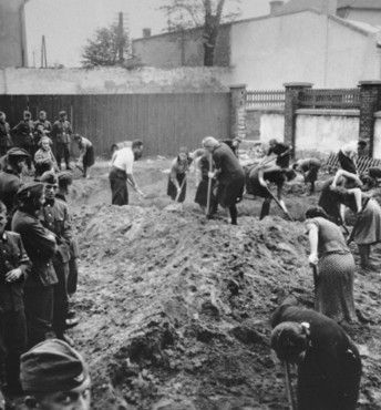 German troops look on as a group of Jews --all but one of whom are women-- dig ditches in a fenc.jpg