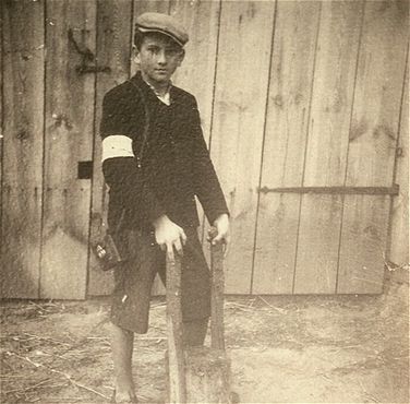 Kolbuszowa and Rzeszów Jewish Life and Ghetto Photos, 1929-1941 - A Jewish youth wearing an armband poses holding a farm implement in the Kolbuszowa ghetto