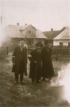 Three elderly Jews walk along an unpaved street in the Kolbuszowa ghetto.jpg