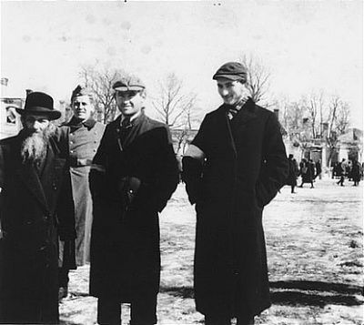 three-jews-pose-public-square-kolbuszowa-ghetto-front-german-soldier.jpg