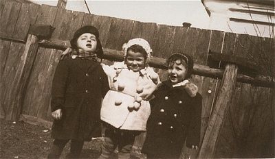 three-young-children-pose-front-wooden-fence-kolbuszowa-ghetto.jpg