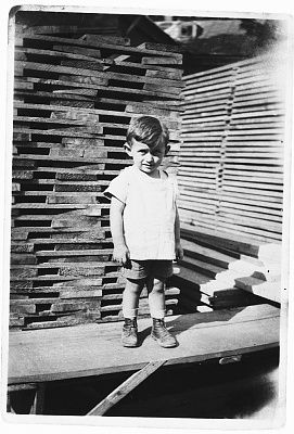 young-jewish-boy-poses-front-stack-lumber-lumberyard-rzeszow-poland.jpg