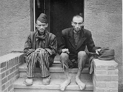 two-emaciated-survivors-sit-outside-stoop-barracks-newly-liberated-nordhausen.jpg