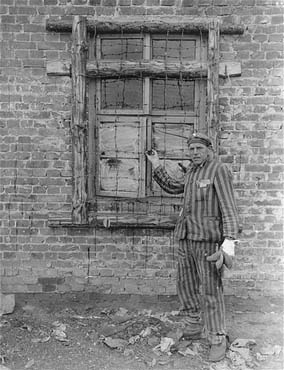 A Dutch survivor liberated in the Woebbelin concentration camp shows the photographer barbed-wir.jpg
