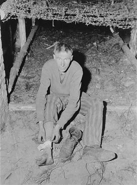 A survivor in Woebbelin shows the photographer where SS guards beat him with a lead filled whip.jpg