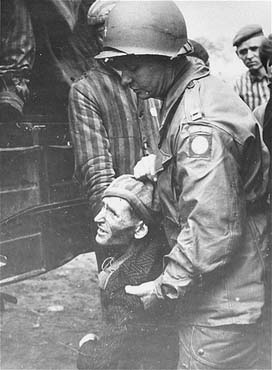 Philip Hannan, a chaplain with the 82nd Airborne Division, helps a prisoner into a truck.jpg
