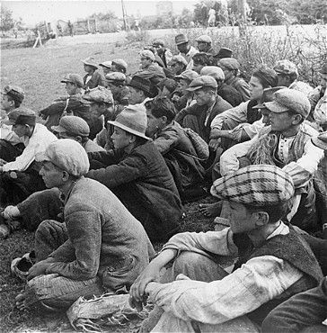 Prisoners seated in a field in the Stara Gradiska concentration camp.jpg